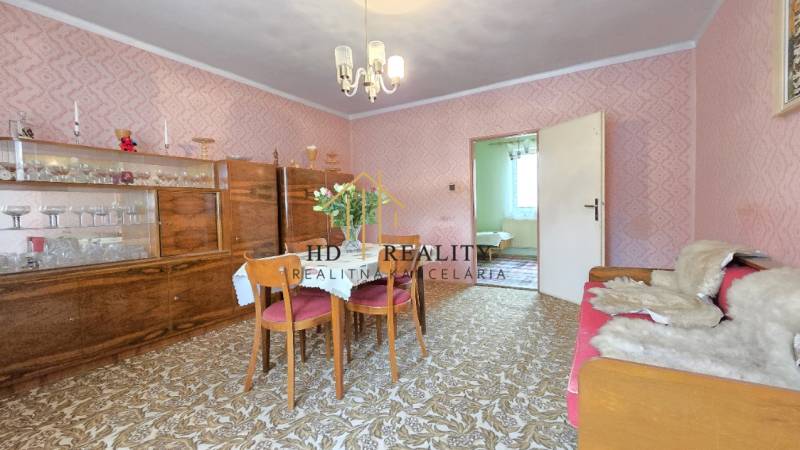 Jedáleň v rodinnom dome s dreveným nábytkom a tapetovanými stenami.