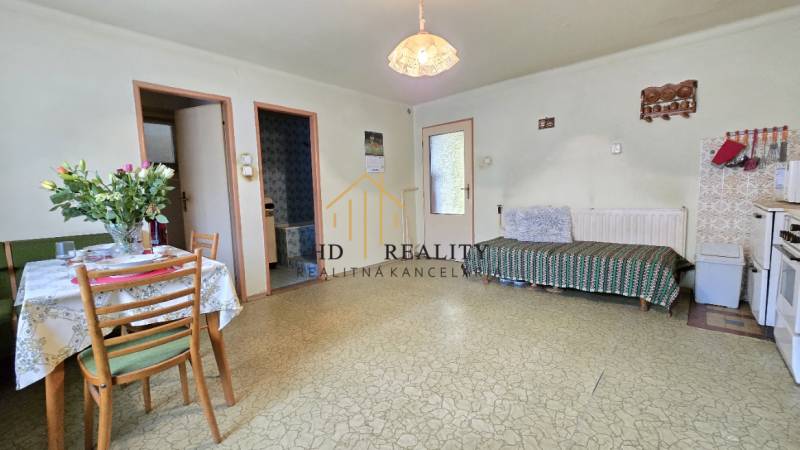 Jedáleň v rodinnom dome so stolom, stoličkami a pohovkou.
