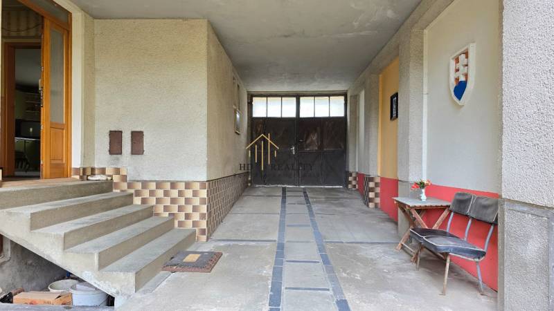 Vstupné schody s lavičkou a kvetmi v rodinnom dome.