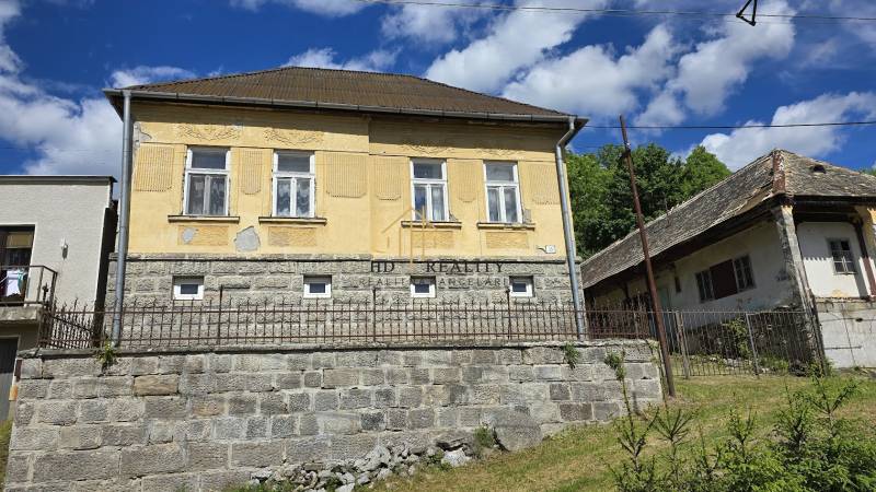 Starší rodinný dom v Chrťanoch s kamenným základom a drevenou strechou.